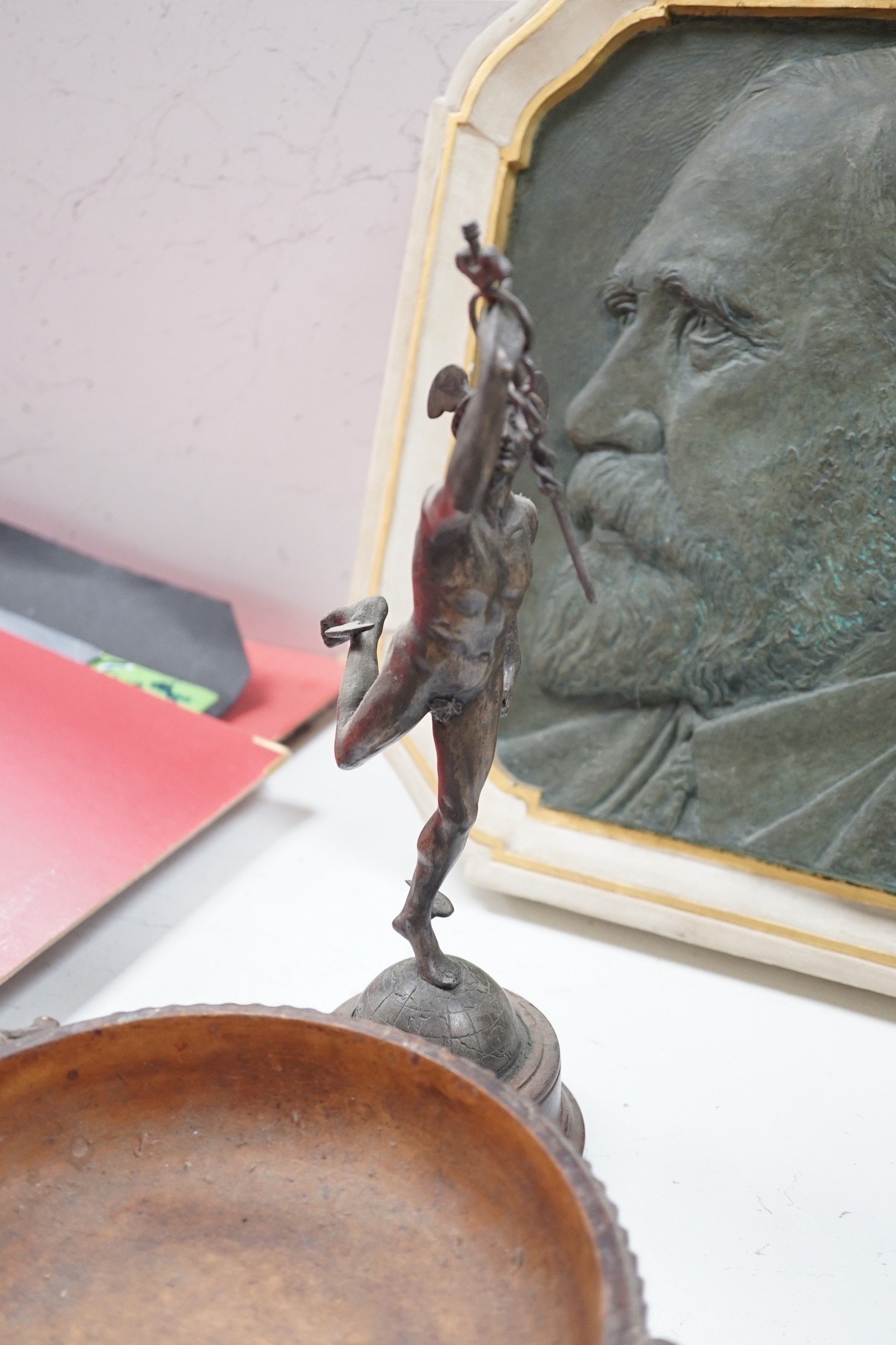 A Spelter figure of Mercury, a musical Black Forest carved wooden bowl, a Chinese carved wood vase stand, two Persian scribes boxes and a painted bronzed plaster plaque (6)